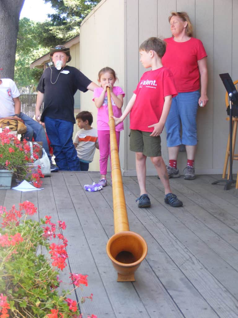 Young girl playing the alphorn at Swiss Kids Camp.
