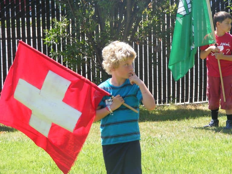 Young boy holding Swiss flag.